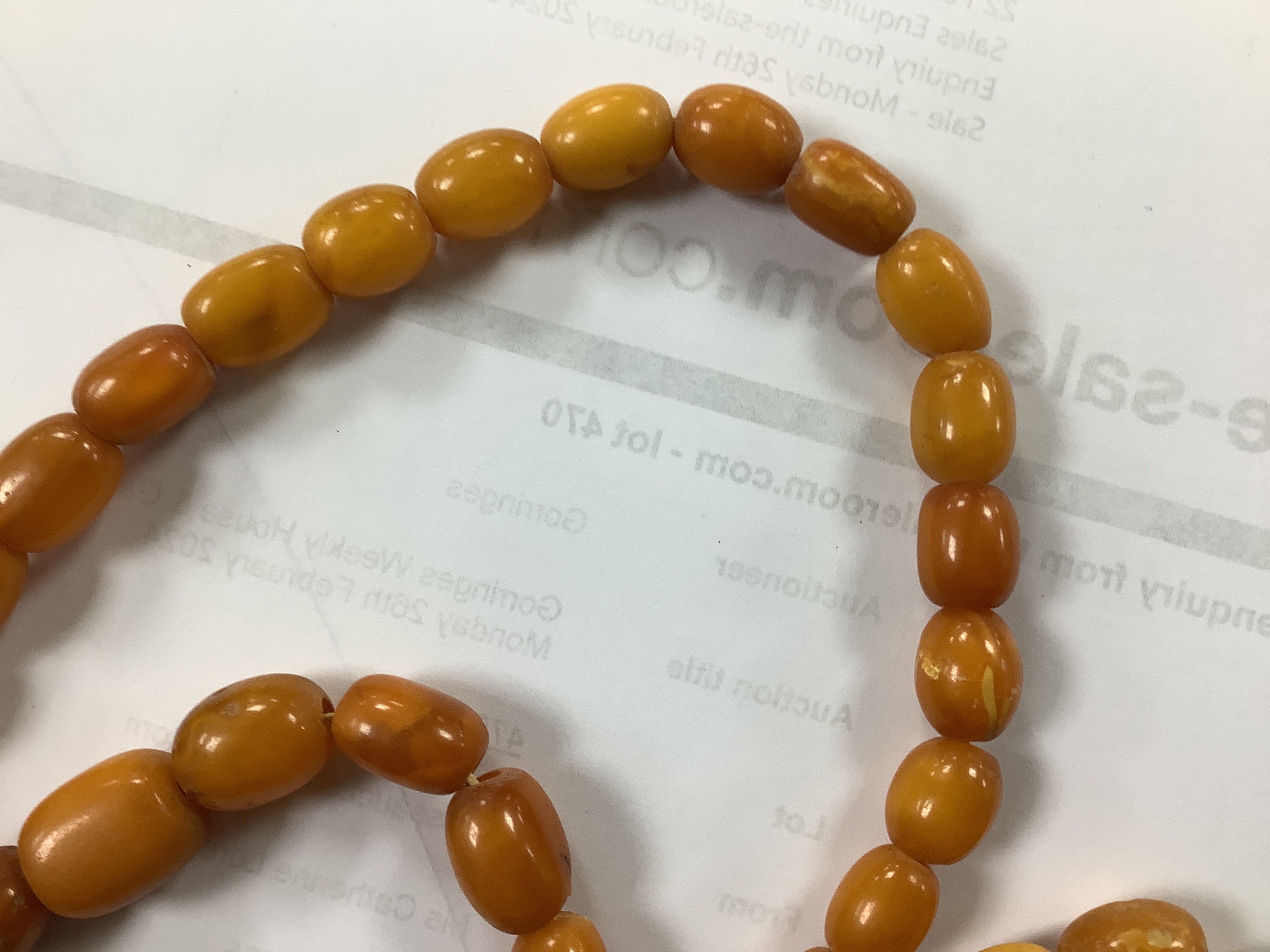 A single strand, barrel and oval amber bead necklace, 108cm, gross weight 76 grams.
